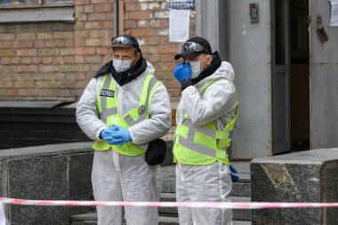 Koruyucu ekipmanlı polis memurları COVID-9 karantinası için binanın girişinde nöbet tutuyorlar. Kyiv, Ukrayna. 