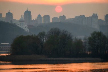 Gün batımında Dinyeper Nehri 'nin ve Kyiv' in sağ yakasının üzerindeki sol kıyıdan görüntüyü al. Ukrayna.