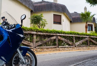 Sokağın sonunda kulübeleri olan bir motosiklet.