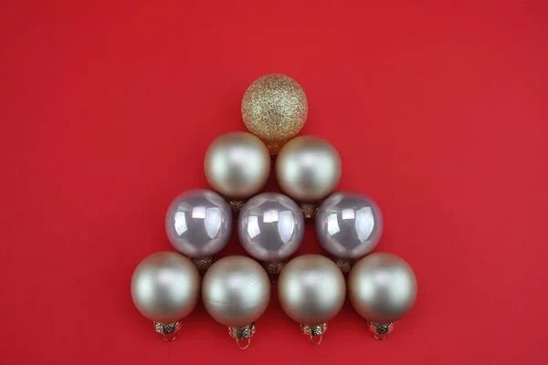 stock image Collage of many Christmas balls in the form of a Christmas tree for the new year. Stylized christmas tree on red background