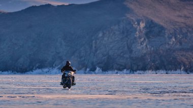 Motorsikletli Harley Davidson donmuş bir gölde.