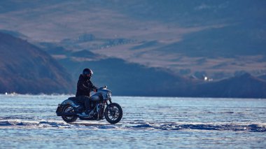 Motorsikletli Harley Davidson donmuş bir gölde.