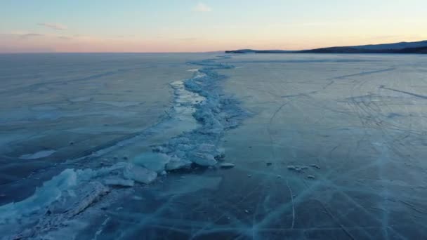 冷凍湖バイカル バイカル湖のハンモック 岩場に近い澄んだ滑らかな氷と美しい冬の風景 有名な天然のランドマークロシア 深い亀裂の青い透明な氷 — ストック動画