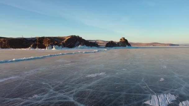 冷凍湖バイカル バイカル湖のハンモック 岩場に近い澄んだ滑らかな氷と美しい冬の風景 有名な天然のランドマークロシア 深い亀裂の青い透明な氷 — ストック動画
