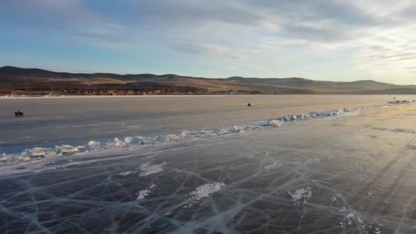 Frozen Lake Baikal, trasporto su ruote sul ghiaccio del lago. Turisti sul lago Baikal, a piedi sul ghiaccio del lago.. Il famoso punto di riferimento naturale della Russia. Ghiaccio trasparente blu con crepe profonde . — Video Stock