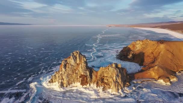 Bevroren Lake Baikal, Cape Burhan Shaman rots van Olkhon Island. Toeristen op het meer Baikal, wandelen op het ijs.. Het beroemde natuurmonument Rusland. Blauw transparant ijs met diepe scheuren. — Stockvideo