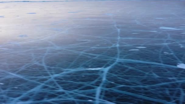 Frozen Lake Baikal, Flygfoto. Vackert vinterlandskap med klar slät is. Berömda naturliga landmärke Ryssland. Blå genomskinlig is med djupa sprickor, utsikt över en frusen sjö. — Stockvideo