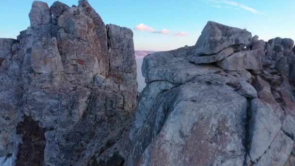 Frozen lake Baikal, Cape Burhan Shaman rock near the village of Khuzhir, Olkhon island. Beautiful winter landscape with clear smooth ice near the rocky shore. Famous natural landmark of Russia. — Stock Video