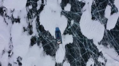 Hovercraft teknesi (Khivus) turist eğlencesi. Donmuş Baykal Gölü, hava manzaralı. Pürüzsüz buzla güzel bir kış manzarası. Rusya 'nın ünlü doğal simgesi. Derin çatlakları olan mavi şeffaf buz