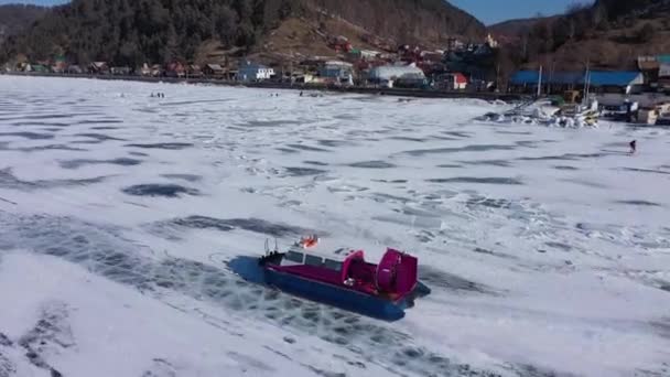 ホバークラフトボート(Khivus)観光エンターテイメント。凍結湖バイカル、空中ビュー。澄んだ滑らかな氷と美しい冬の風景。有名な天然のランドマークロシア。深い亀裂の青い透明な氷 — ストック動画