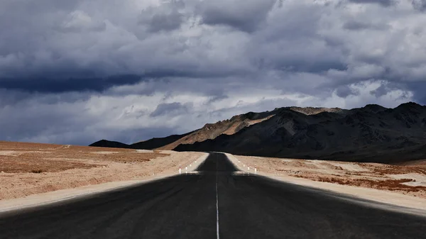 Road to the mountains. Paved road on the background of mountains. Road photography, Traveling by car.