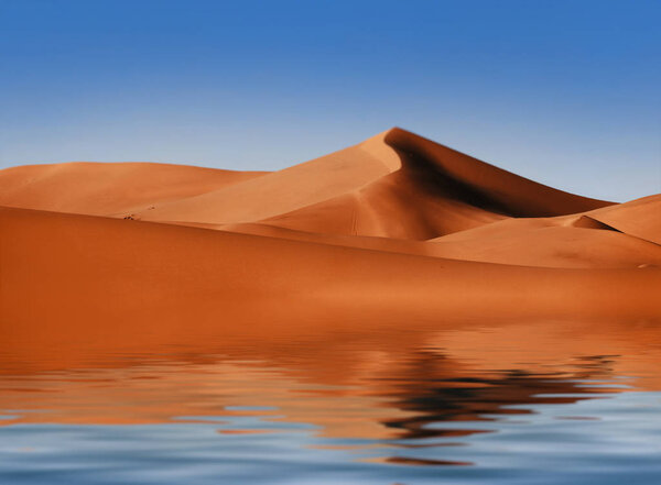 Beautiful sand dunes are reflected in the water. View of the sand dunes.