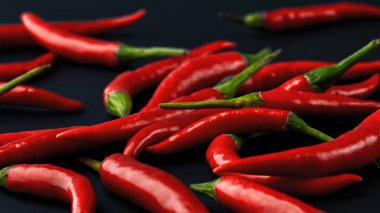 Siyah arka planda kırmızı kırmızı kırmızı biber. Gerçek erkekler için baharat. Ateş çeşnisi.