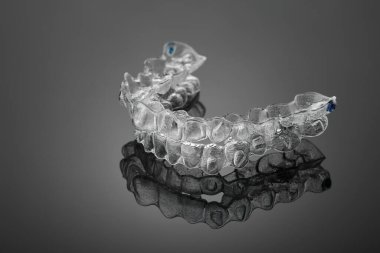 Siyah arka planda görünmez ortodonti kozmetik parantez, diş hizalayıcılar, plastik diş telleri. Güzel bir gülümsemeye ve beyaz dişlere sahip olmanın bir yolu..
