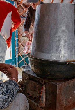 Moğol yurdunun hayatı. Göçebenin evinin içi. Adam ev yapımı alkol tatmak için biraz ev yapımı bira koyuyor. 06.09.2019. Gobi Çölü, Moğolistan.