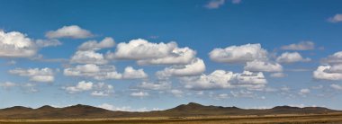 Gobi Çölü 'nün Panorama' sı, Moğolistan 'ın Alanı ufuktaki dağlar, bulutlu mavi gökyüzü. Atmosferin dinginliği.