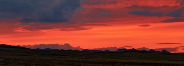 Dağlarda inanılmaz bir gün batımı. Doğanın renkleri. Dağların arkasında günbatımı manzarası.
