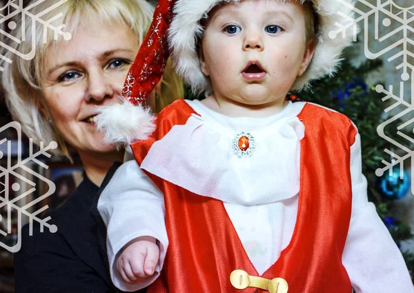 Cute baby dressed as Santa Claus and his grandmother — Stock Photo, Image