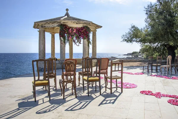 Arco de boda decorado a orillas del Mediterráneo. Hermosa boda decorada y romántica. Gazebo de piedra decorado para la ceremonia de boda . —  Fotos de Stock