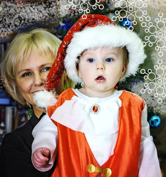 Schöner kleiner Junge im Weihnachtsmann-Kostüm mit Oma — Stockfoto