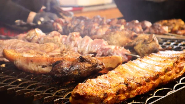 Costeletas de porco fritas. kebabs de porco grelhados em um bule de chá. Barbecue Kid no grelhador. kebab grelhado, kebab. Festival de deliciosa comida frita de rua. A carne no osso, o processo de cozimento — Fotografia de Stock