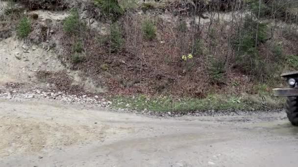 Ucraina, Yaremche - 20 novembre 2019: un grande camion con un corpo vuoto guida lungo una strada sterrata nella foresta alla ricerca di tronchi appena segati. Trasporto di legname su strada su strada di montagna con rimorchio — Video Stock