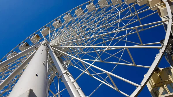 Grande roue blanche ferris contre le ciel bleu. Une partie de l'attraction sur un fond bleu avec de l'espace de copie. Cabines, plates-formes d'observation . — Photo