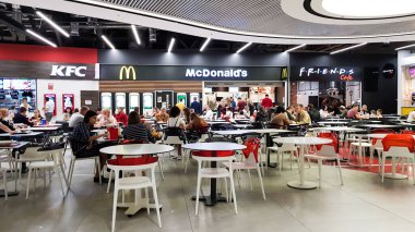 Ukrayna, Kiev - Mart 06, 2020. Alışveriş ve eğlence merkezinde insanlar olan fast food alanı. McDonald 's ve KFC. Kafenin ziyaretçileri ve misafirleri restorandaki masalarda fast food yiyorlar.