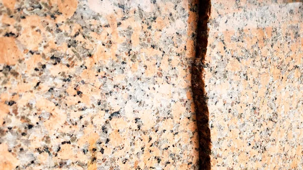 Doğal kahverengi granit desenli, cilalanmış mineral dilimli. Kusursuz çatlamış mermer, hasarlı beton doku. Mimarlık geçmişi. Taş zeminde kahverengi lekeler var. bilye.