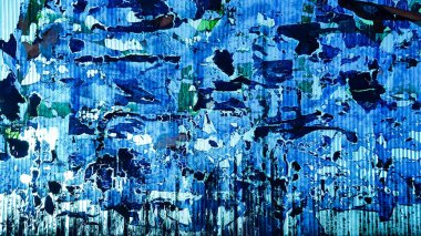 Dalgalanmamış plastik yüzey, tuhaf film ve kağıt kalıntılarıyla. Soyut işlevsiz mavi arkaplan. Uzayı kopyala, tasarım. Tahıl mavisi duvar arkaplanı veya dokusu.