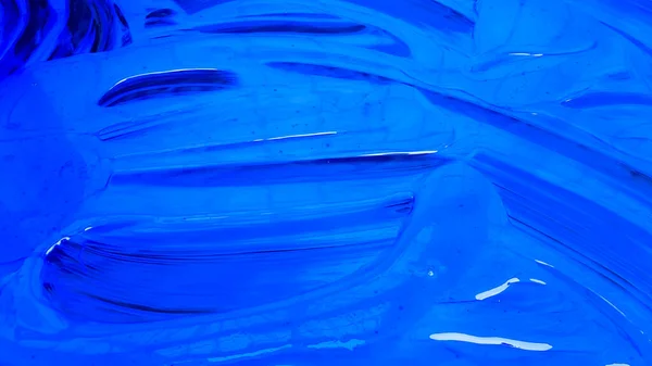 Abstract background of spilled blue paint with buckets on a black background. Blue paint is pouring on a black background. Use it for an artist or creative concept. Paints spilled blue background.