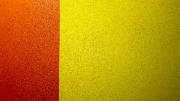 赤と黄色の塗装壁のテクスチャコピースペースと抽象的なグランジの背景 壁に抽象的な幾何学模様 壁は異なる色の境界に分かれています — ストック写真