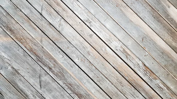 Gray wooden background with diagonal lines. Board background with copy space. Wooden old boards with cracked gray paint on the diagonal. Selective focus. Textured wooden background