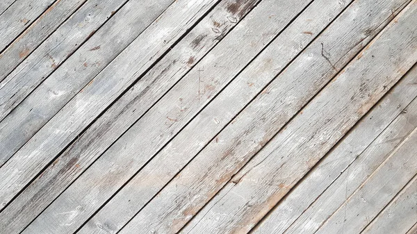 Gray wooden background with diagonal lines. Board background with copy space. Wooden old boards with cracked gray paint on the diagonal. Selective focus. Textured wooden background