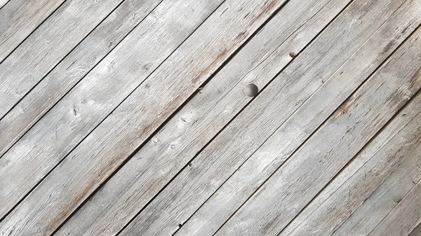 Çapraz çizgileri olan gri ahşap bir arka plan. Kopya alanı olan bir tahta arkaplan. Çaprazında çatlak gri boya olan ahşap tahtalar. Seçici odaklanma. Desenli ahşap arkaplan