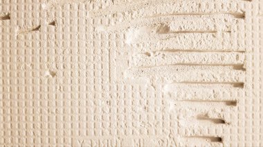 Vites desenli bir fayans için yapıştırıcı. Döşeme döşemesi. Duvarın yüzeyi döşemeden önce yapıştırıcı macunla ya da dekoratif taşla kaplıdır. Onarım ve yenileme konsepti