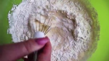 Fırın malzemelerini çırpmak için çırpılmış unla yumurtalara karıştırılmış un yakın plan. Un ve sütün yumurta sarısını yakın. Krep yapma süreci. Bir dizi çerçeve adım adım bir tariftir