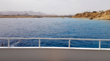 Mısır 'daki Kızıl Deniz' deki bir yolcu gemisinin güvertesinden güzel bir manzara. Bir yatı olan Mısır kayalık kıyı manzarası. Geminin bir kısmı çöl ve denizin arka planına karşı.