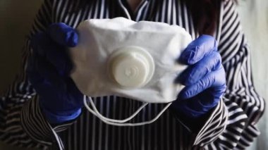 Bir kadın, taç virüsünü önlemek için koruyucu bir maske takıyor. Kendilerini koronavirüs salgınlarından ve salgınlardan koruyan patojenlerin bulaşmasını engeller.