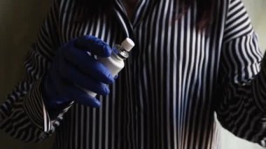 Kıza bakteri ve koronavirüslerden korunmak için mavi eldivenli antiseptik eller sıkılmış. Kadın ellerini antiseptikle kapatın. Covid-19 'daki viral enfeksiyonlara karşı koruma.