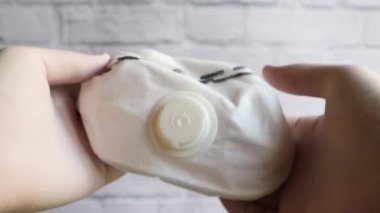 Birinci elden bir doktor koruyucu beyaz tıbbi eldivenlerde solunum maskesi gösteriyor. Coronavirus salgını sigortası. Kapakçıklı beyaz tıbbi maske. Havadan bulaşan hastalıklara karşı koruma