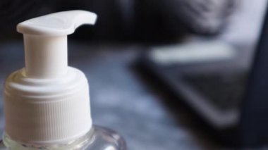 Seçici odaklı bir şişe ağzındaki yakın plan görüntü. Kadın eli bir doz antiseptik veriyor. Bulanık bir arka planda ellerinizi bakteri ve virüslerden yıkayın. El dezenfeksiyon