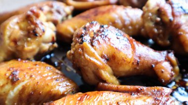 Tavada kabuğu olan kızarmış tavuk kanadı. Fırında teriyaki soslu fırında pişirilmiş tavuk, seçici bir odak noktası.