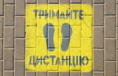 Ukrayna, Kiev - 23 Nisan 2020. Sarı kaldırıma dikkat edin. Kaldırımdan uzak durun. Metin Ukraynaca. Sosyal mesafeyi, karantinayı veya izolasyonu koruma kavramı.