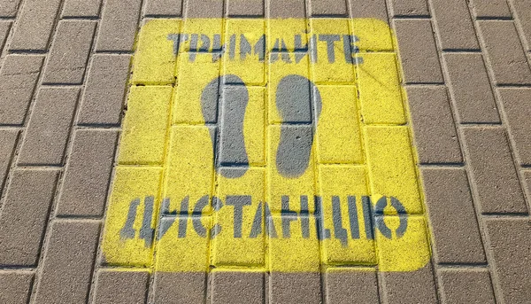 乌克兰 2020年4月23日 黄色人行道上的警告保持你在人行道上的距离 该文本以乌克兰语写成 保持社会距离 隔离或孤立的概念 — 图库照片
