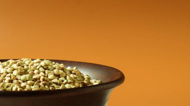 Kahverengi arka planda kahverengi kil tabakta çiğ yeşil karabuğday. Vegan organik gıda konsepti. Diyet konsepti, kilo kaybı, sağlıklı ve düzgün beslenme. Metin veya logo için boşluk kopyala