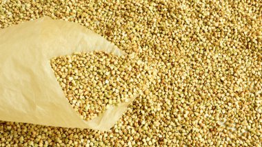 Yeşil karabuğdaylı kağıt bir torba yalan söyledi. Kese kağıdında taze taze karabuğday taneleri. Beslenme gıdaları. Uzayı kopyala Vejetaryenlik, dengeli ve sağlıklı beslenme kavramı