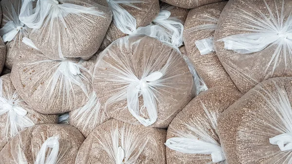 Virüs salgını sırasında alışveriş. Market çalışanları ya da market müşterileri için güvenli alışveriş için süpermarket çalışanları tarafından poşetlere doldurulmuş karabuğday. Salgın. Koronavirüs