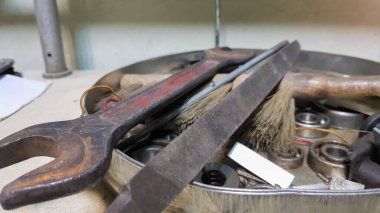 Tahtada ve atölyede iş aletleri var. Atölye sahnesi. Kirli bir masaüstünde bir sürü eski alet. Marangozluk ve resim konsepti