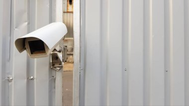 Gri kıvrımlı metal çitin tepesindeki güvenlik kamerası..
